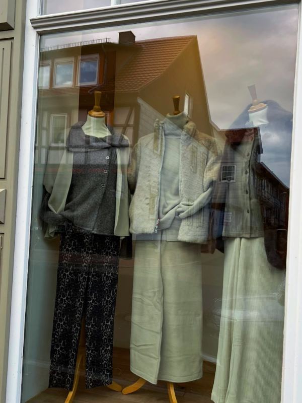 Schaufenster von ELLA mit drei Puppen in Strick, Fleecejacke und weiten Hosen
